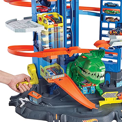 Hot Wheels Megagaraje con T-Rex Robótico - Ascensor y 4 Niveles - Plazas para 100 Coches 1:64 - 2 Coches 1:64 Incluidos - Regalo para Niños de 3+ Años